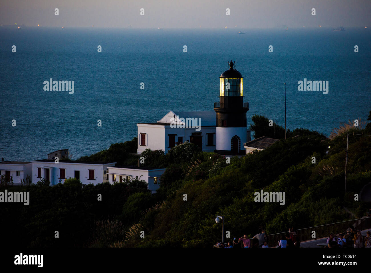 Flower and Bird Island Lighthouse, Fluorescent Sea and Sunset Stock Photo