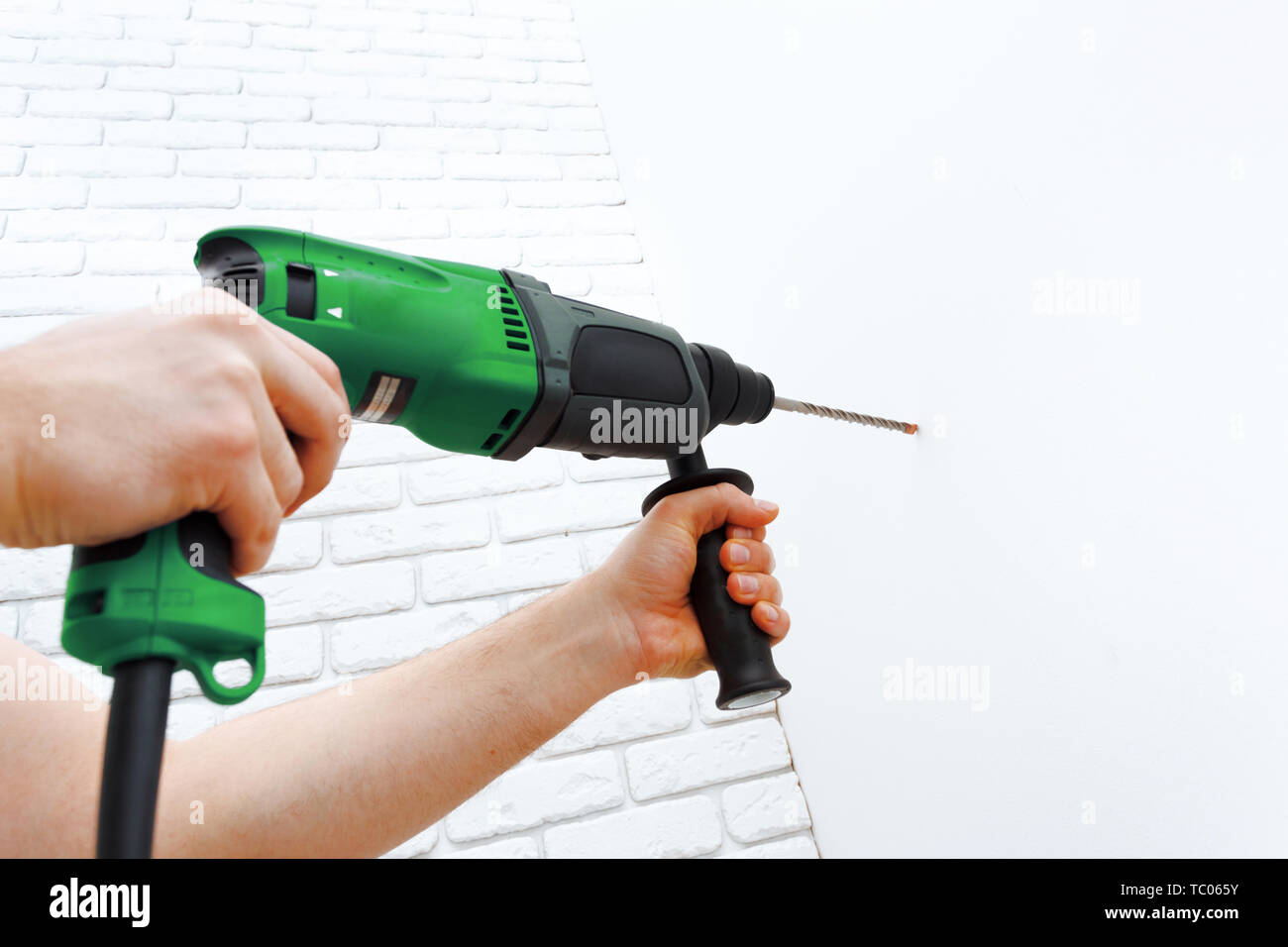 Use hammer drill to drill the wall Stock Photo Alamy
