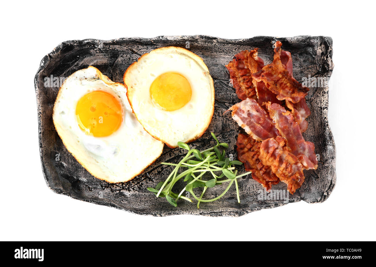 Plate with tasty fried eggs and bacon on white background Stock Photo ...
