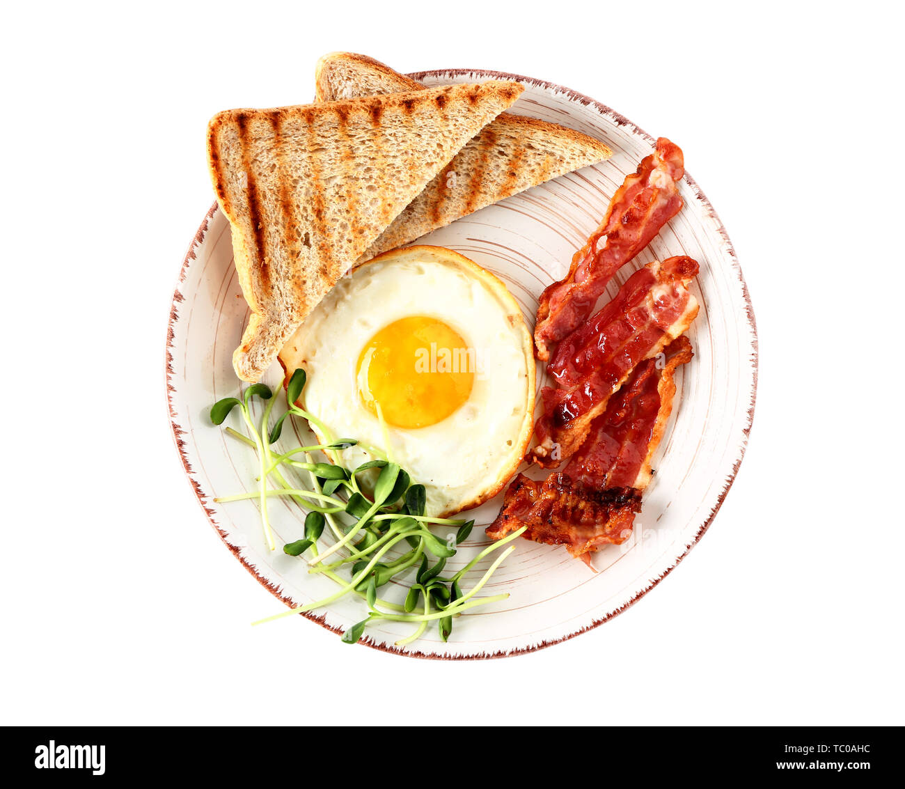 Plate with tasty fried egg, bacon and toasts on white background Stock ...