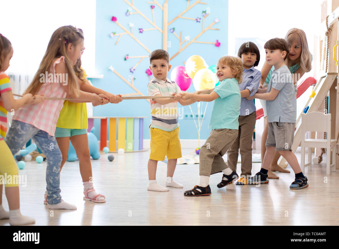 Group of children in a ropepulling contest in daycare Stock Photo Alamy