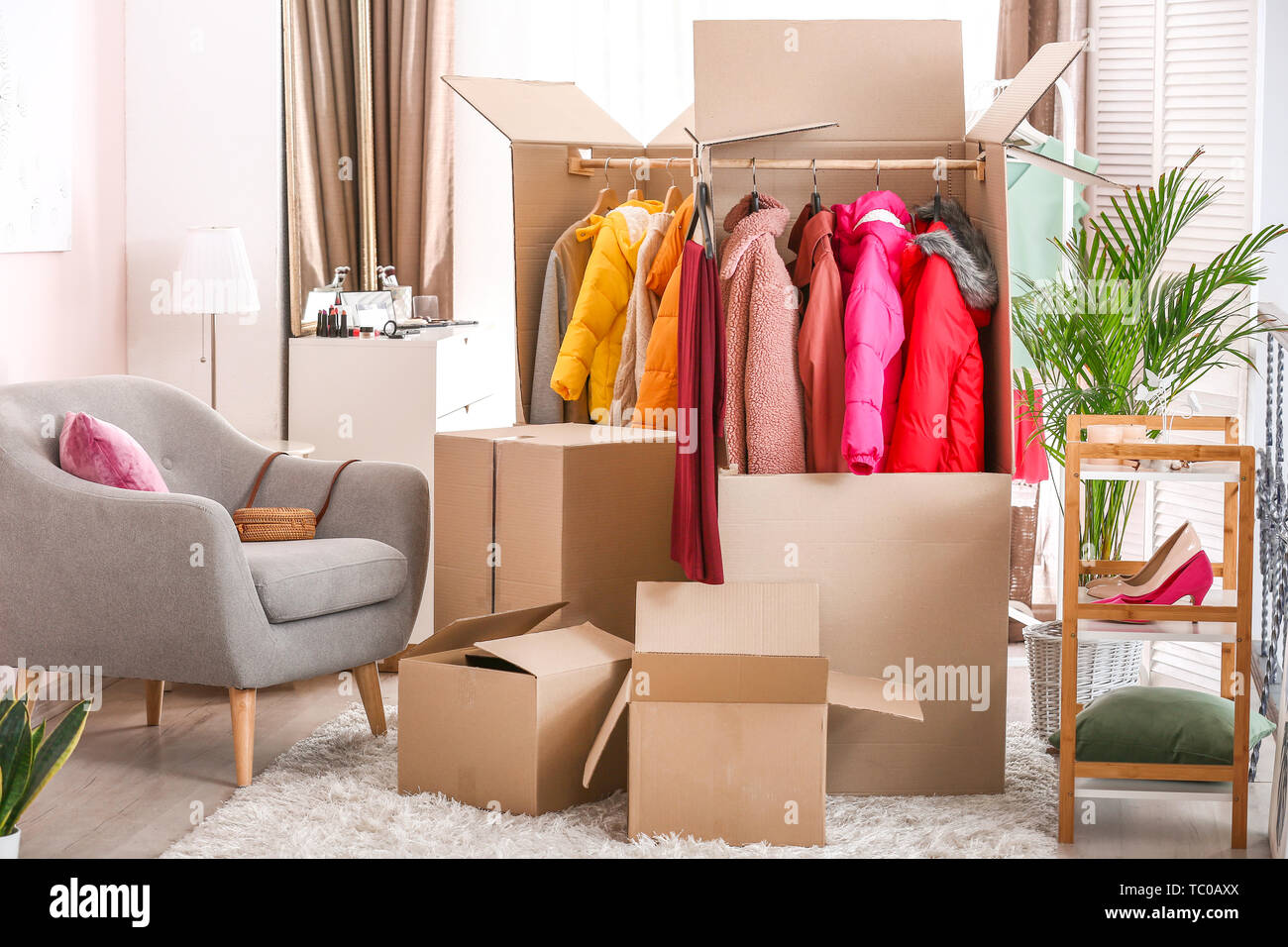 Wardrobe boxes with clothes in room Stock Photo Alamy