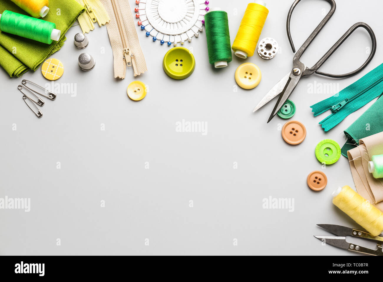 Sewing threads and accessories on light background Stock Photo - Alamy