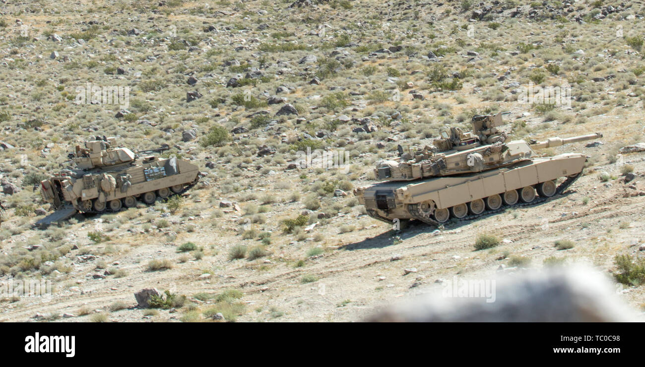 Oregon Army National Guard Soldiers from Bravo and Charlie companies, 3-116th Cavalry Regiment, 116th Cavalry Brigade Combat Team, conduct armored troop leading procedures and dismounted infantry operations June 1, 2019, at the National Training Center at Fort Irwin California.  NTC provides Soldiers in a combined armored battalion with experience training together across different weapons system platforms.         The 116th Cavalry Brigade Combat Team is training at the National Training Center May 24 through June 20 to prepare for its wartime mission. The rotation builds unit and Soldier pro Stock Photo