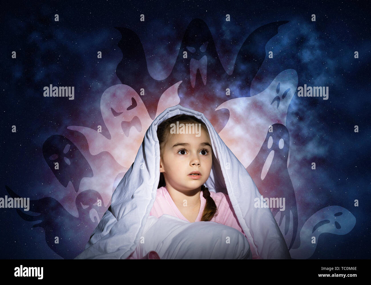 Scared girl with pillow hiding under blanket Stock Photo Alamy