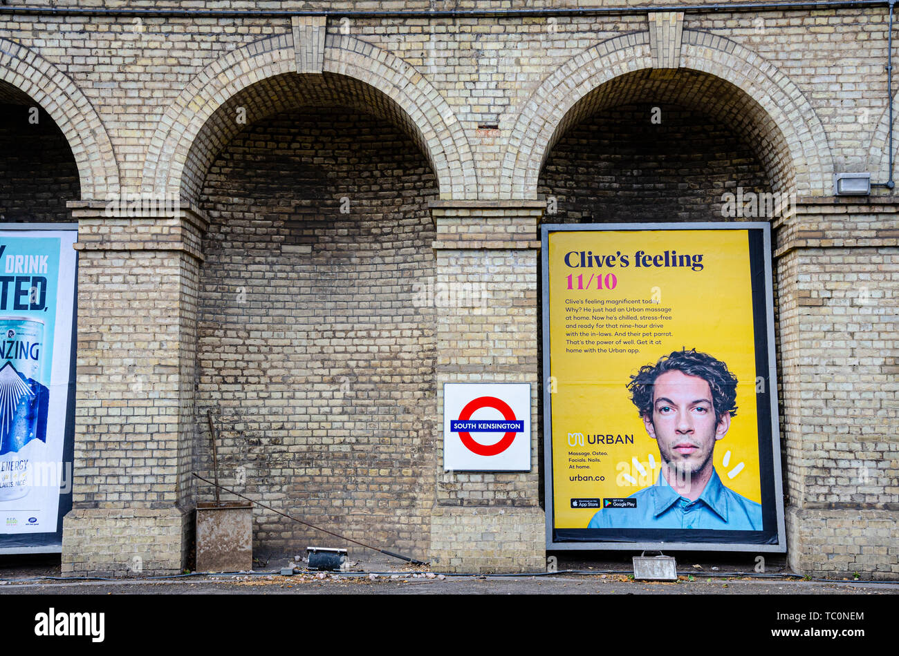 An advertising board under an archway on a platform which is no longer used  at South Kensington London Underground Station Stock Photo - Alamy