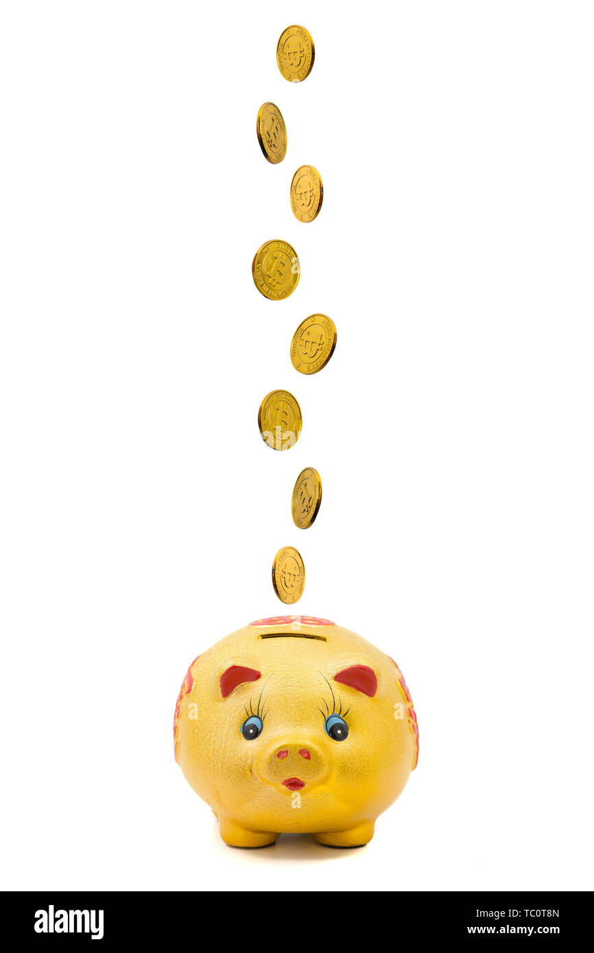 A string of coins falling down into a piggy bank against a white ...
