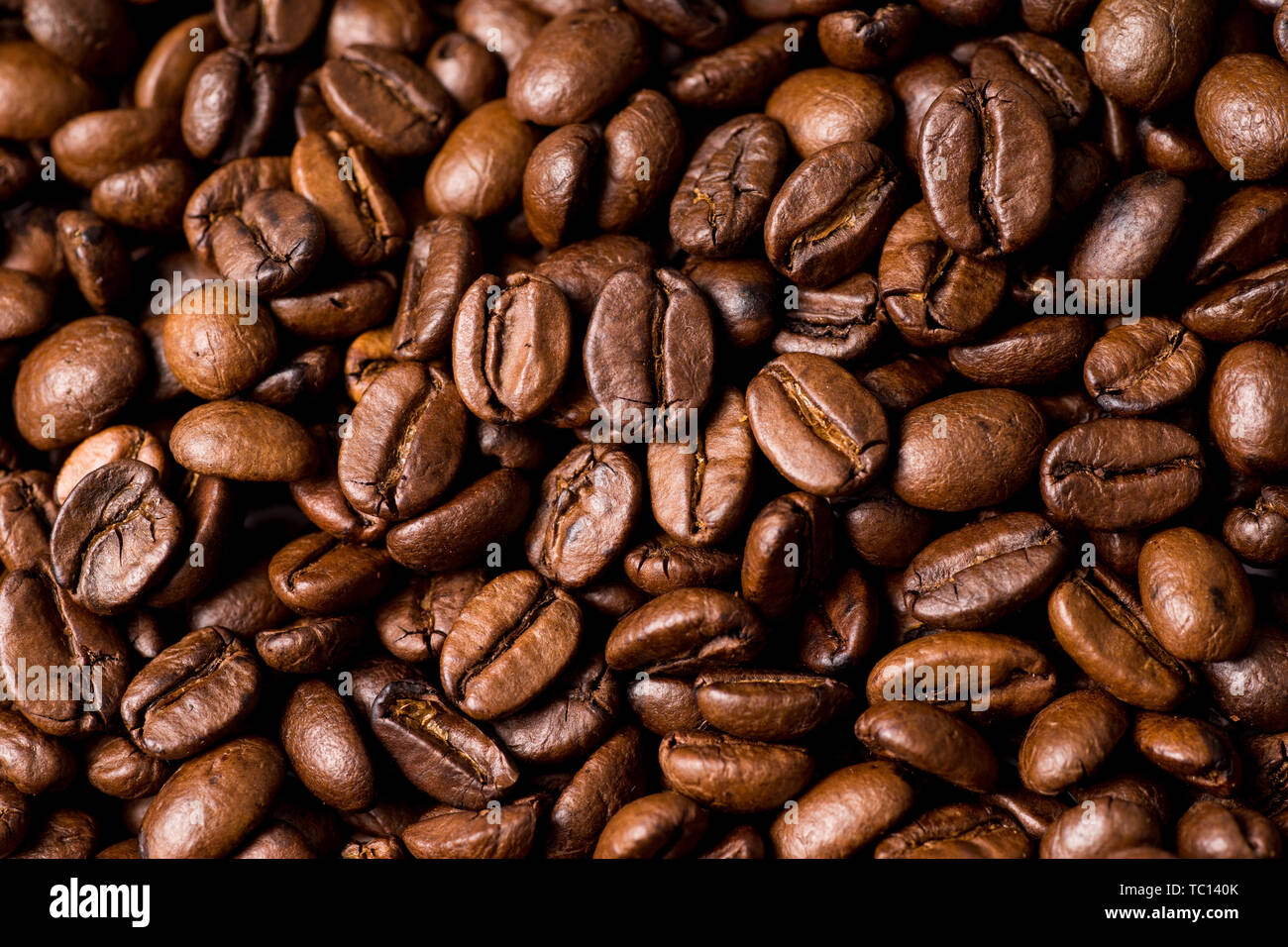 Roasted organic whole dark coffee beans, close up Stock Photo