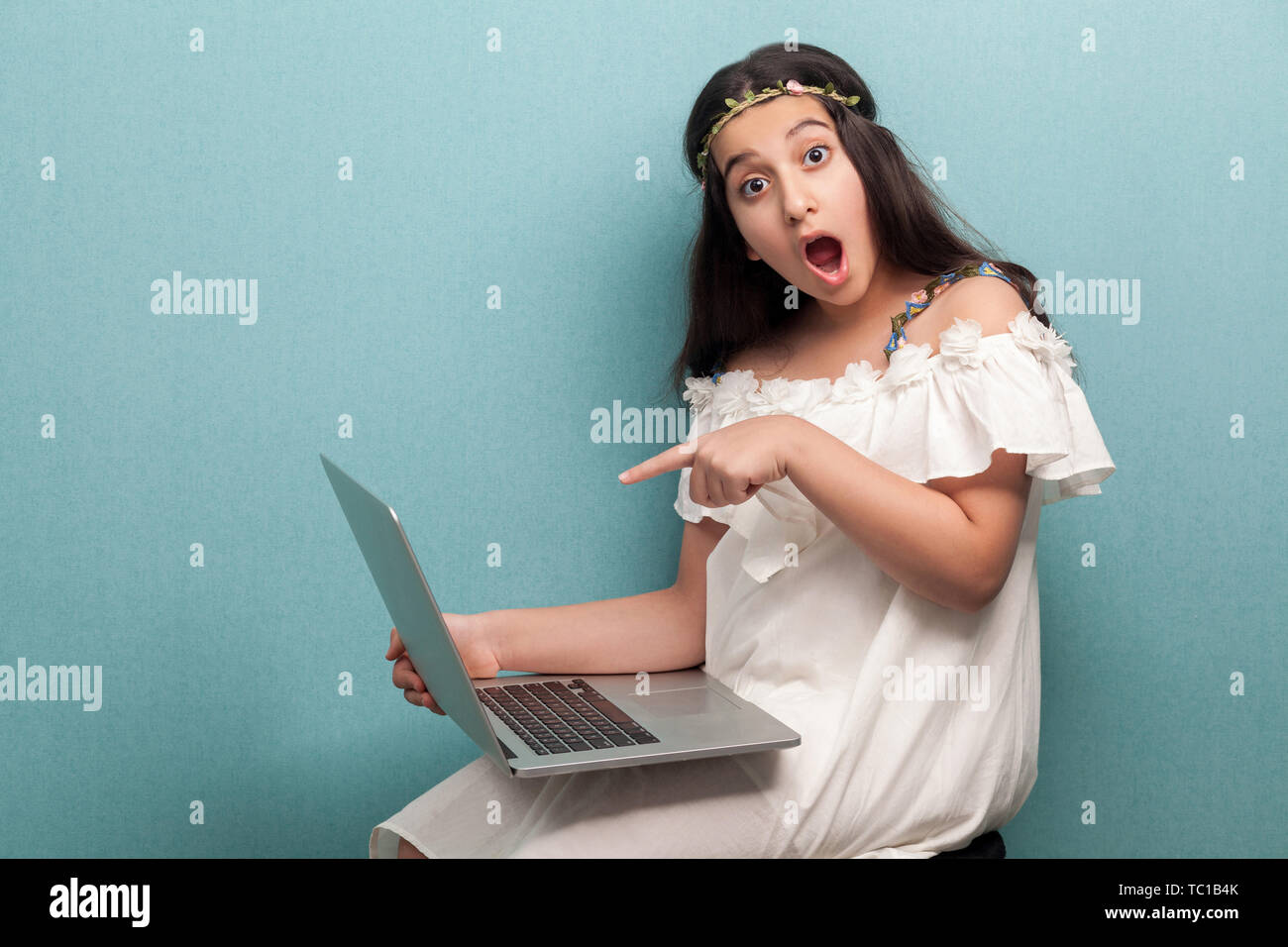 Beautiful shocked teenager girl with long black hair in white dress ...