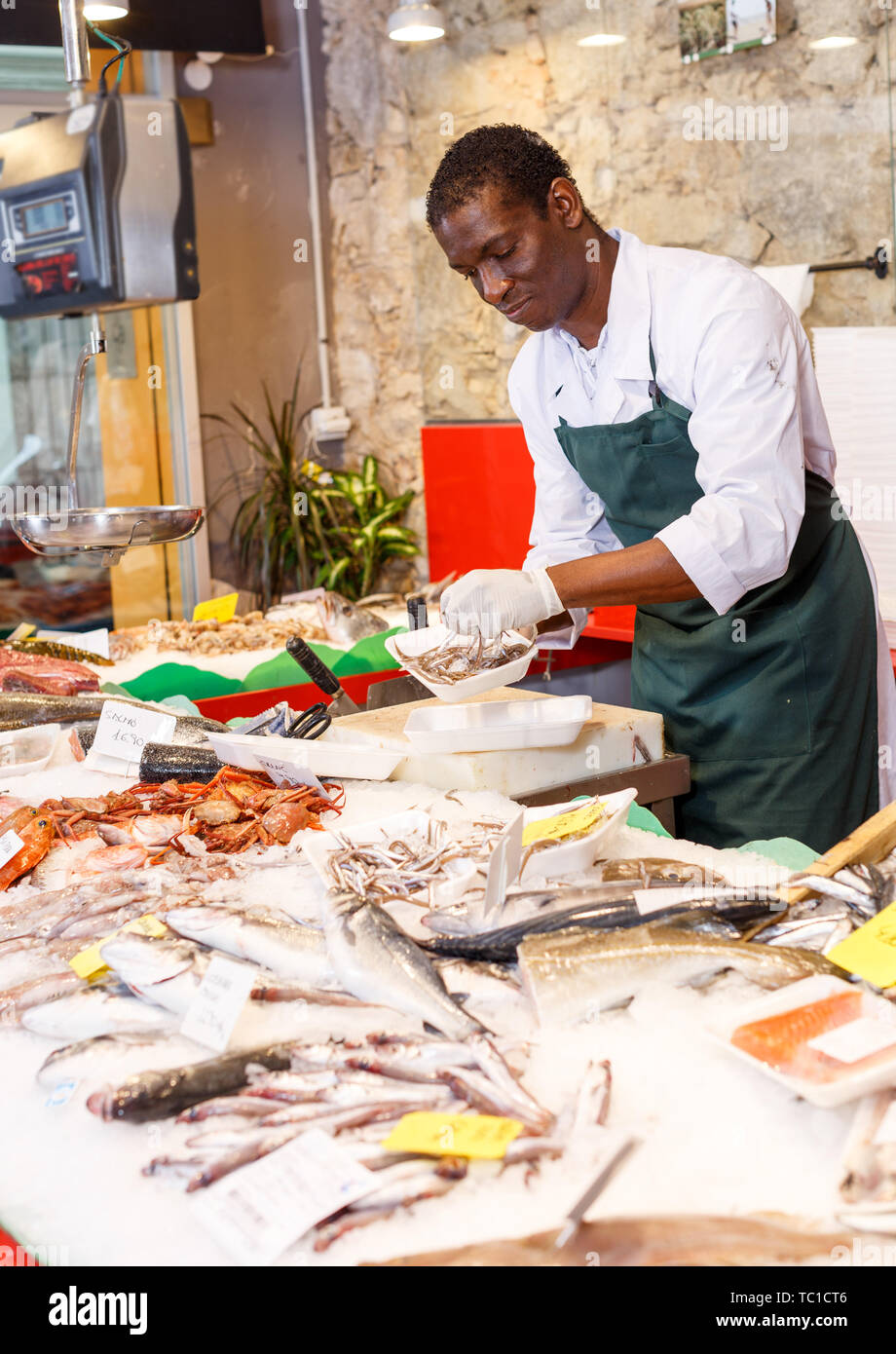 Positive male worker preparing fresh fish for sale Stock Photo - Alamy