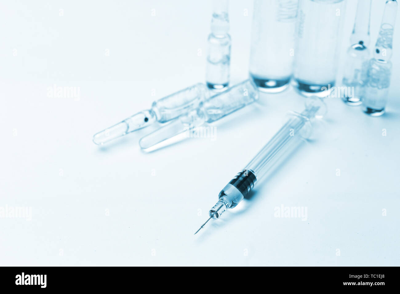 glass syringe in front of medicine bottles in blue tone Stock Photo - Alamy