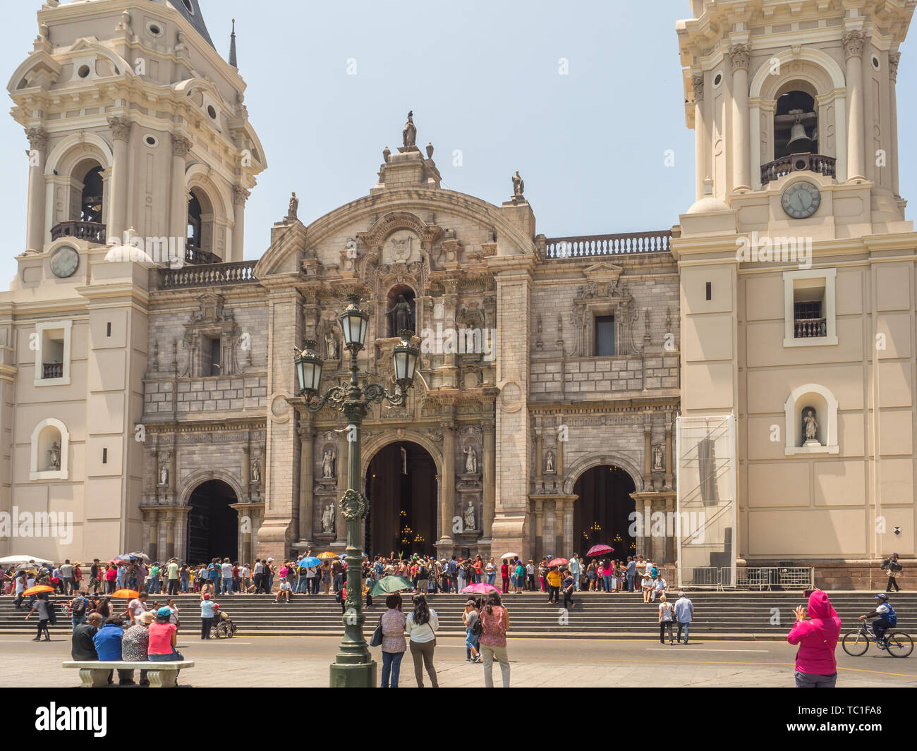 Lima, Peru - March 29, 2018: People with colorful umbrellas on a hot day on the street of Lima next to Parroquia del Sagrario. Easter time. Good Frida Stock Photo