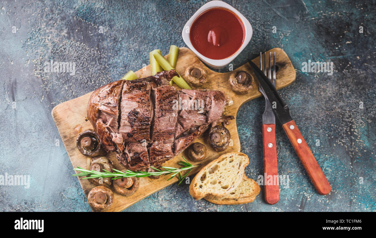 Baked lamb with mushrooms, spices and herbs on a concrete background. Halal meat and food Stock Photo
