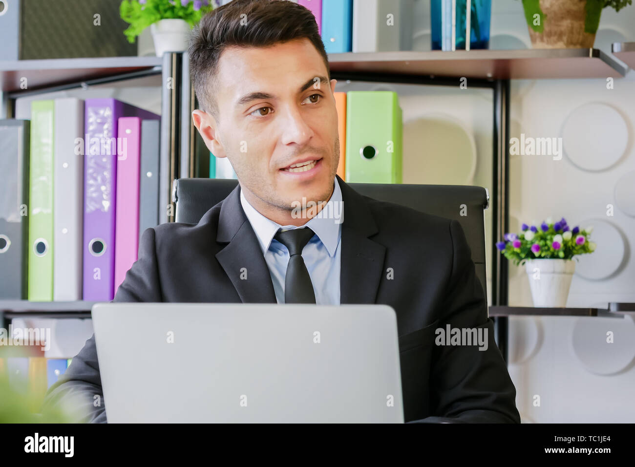 portrait business man work in modern office talking with laptop computer and talking to someone Stock Photo