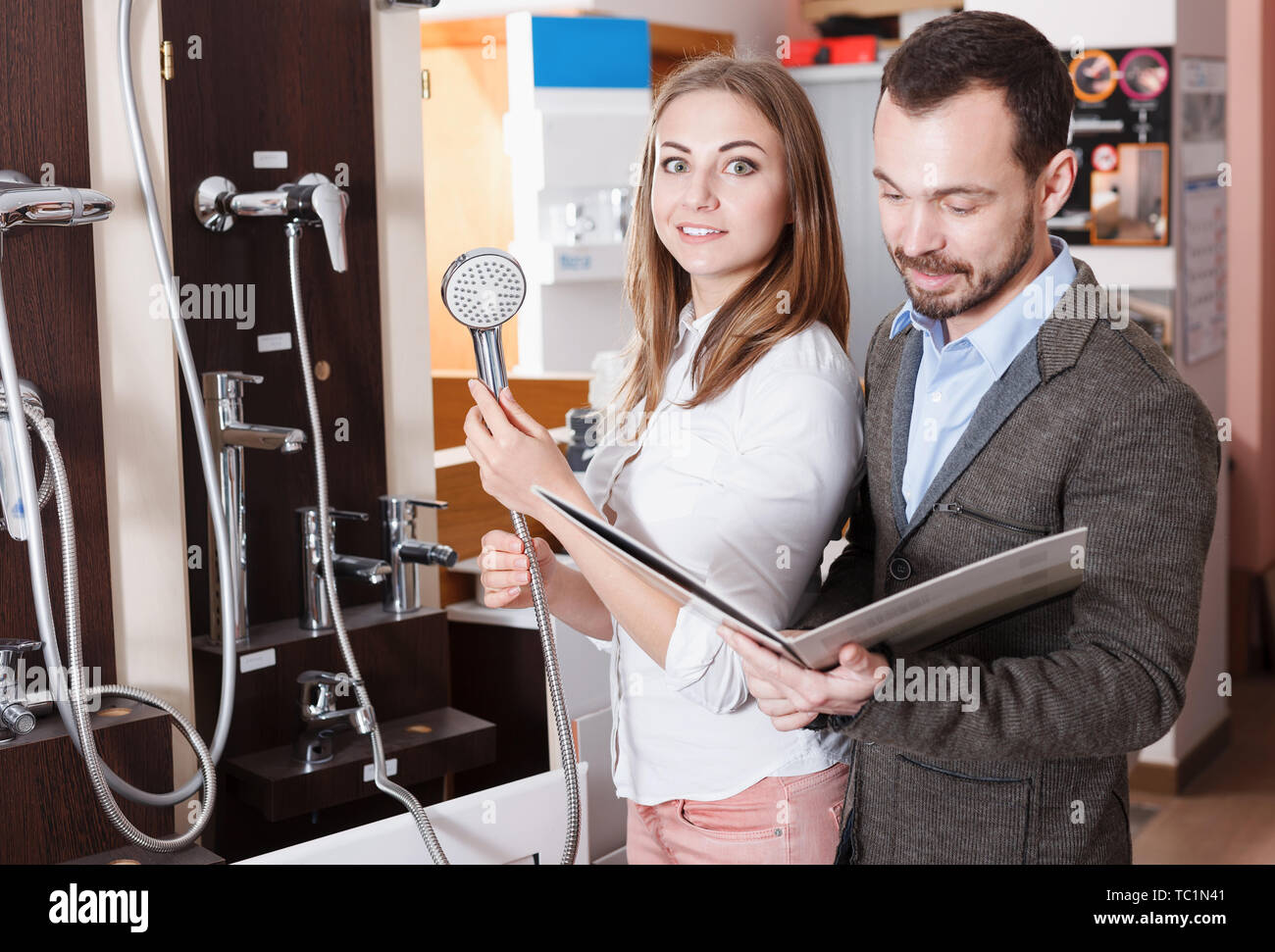 Family couple choosing modern functional shower mixer in store Stock