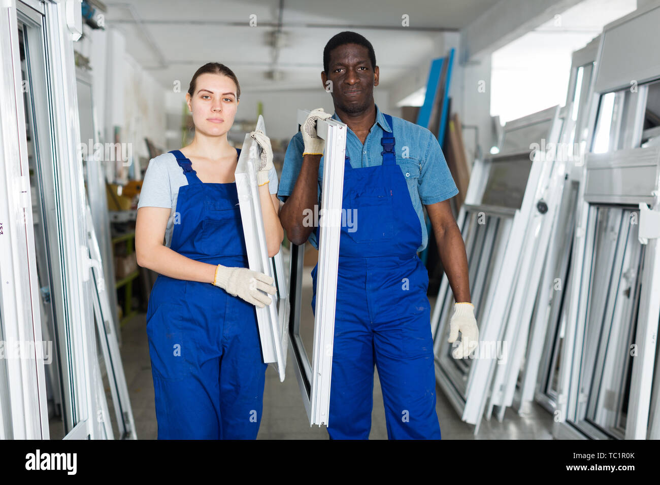 Two masters are working with window frame in the window workshop. Stock Photo