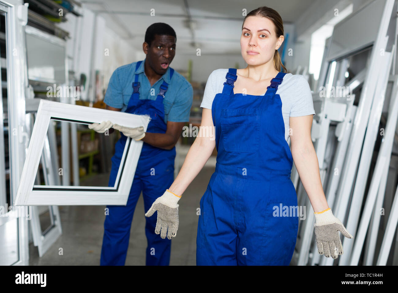 Two masters are conflicting in time working with window frame in the window workshop. Stock Photo