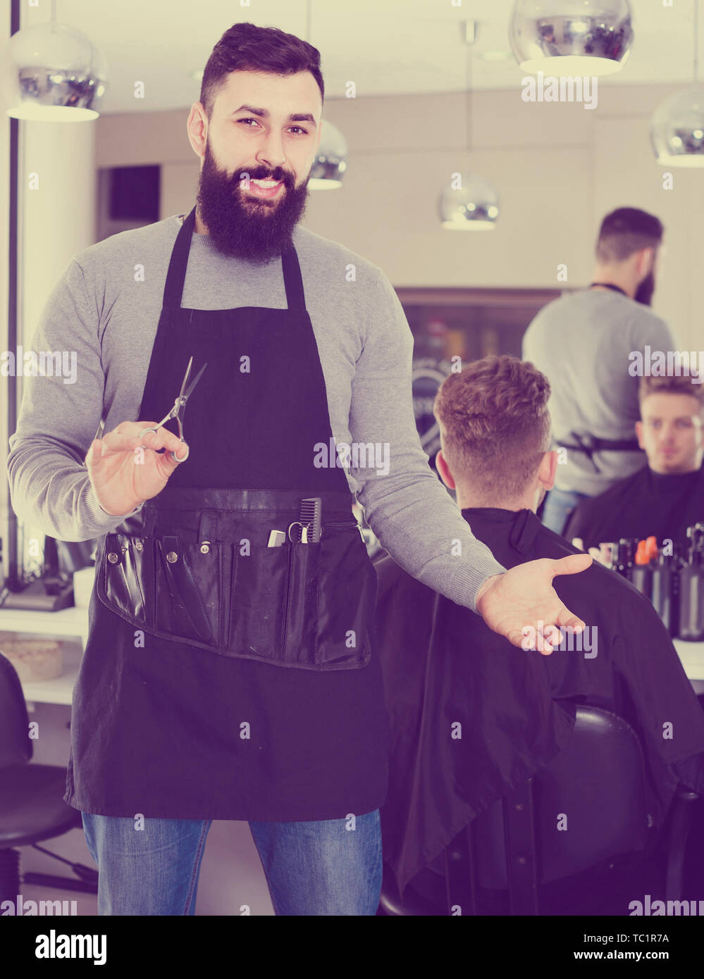 Young Spanish Male Hairdresser Showing His Workplace And Tools At