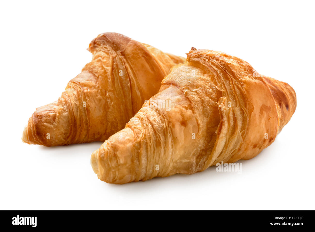 Two baked plain croissants isolated on white. Stock Photo