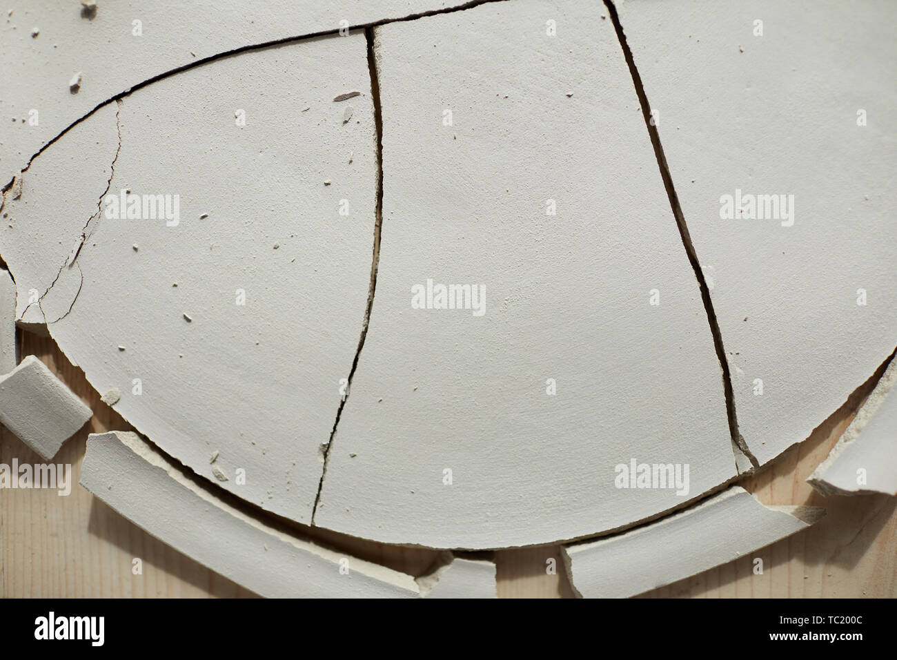 Top view background of cracked ceramic plate on wooden table in pottery workshop, copy space Stock Photo