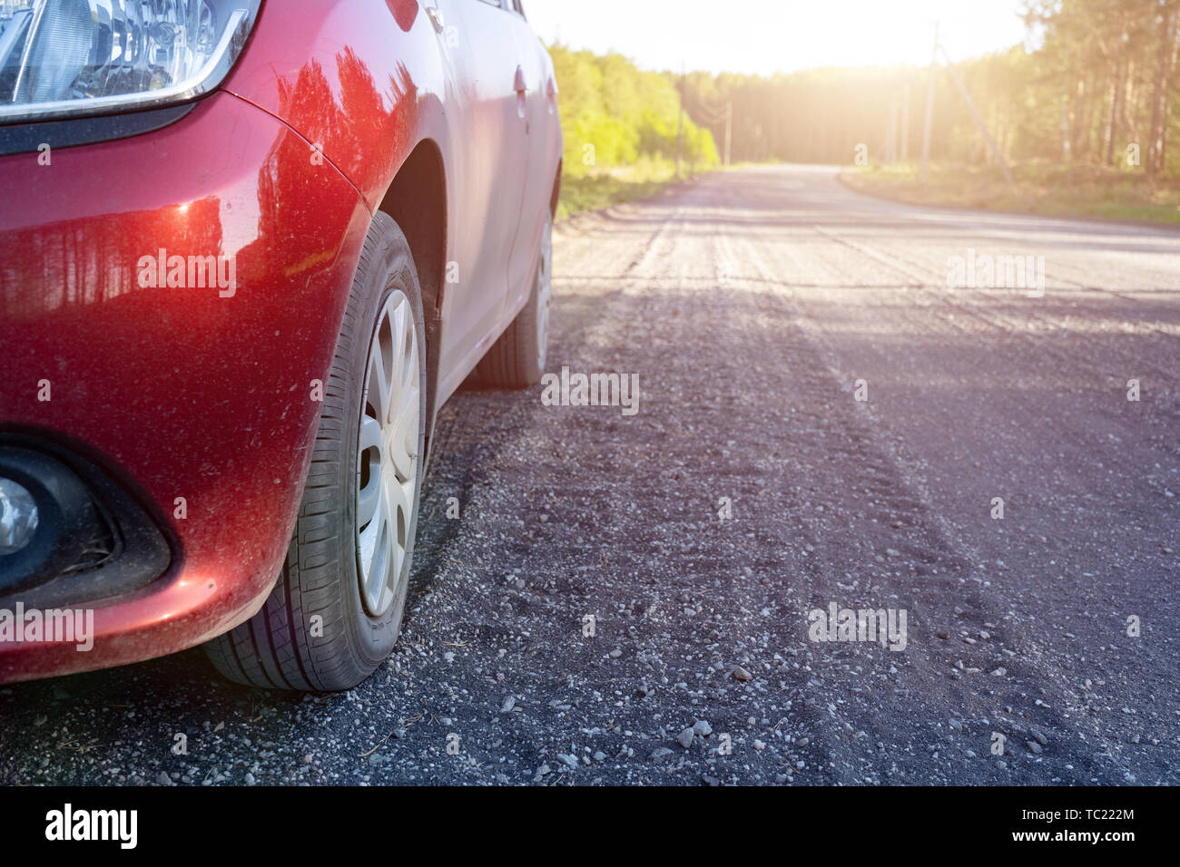 Dusty cars on a country road, small rubble on the road. Close up of car tires on dirt country road in summer afternoon. Stock Photo
