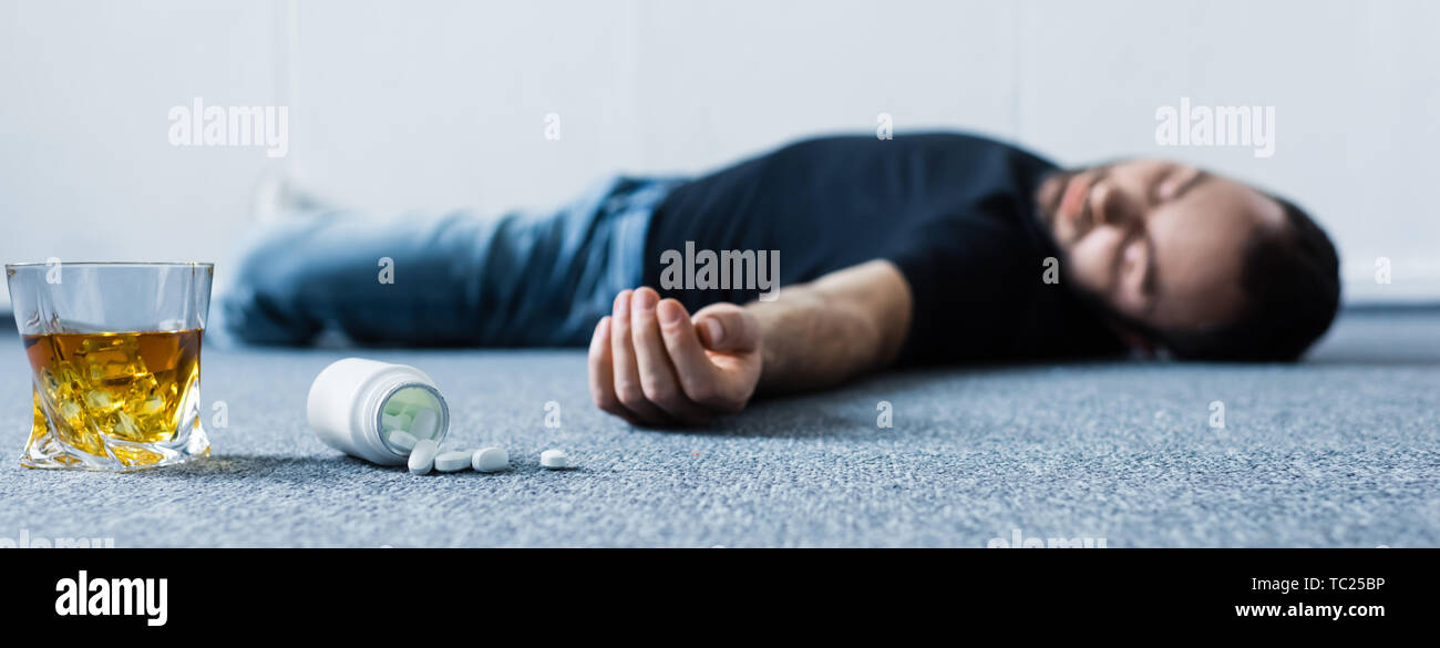 Организм после запоя. Человек с таблетками на полу без сознания. Лежит после запоя.