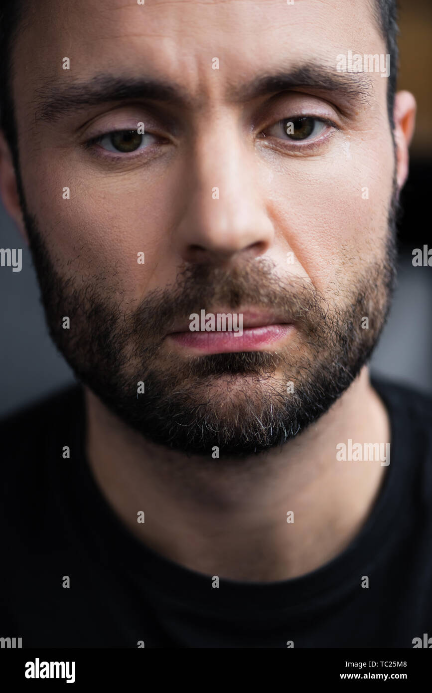 portrait of frustrated, depressed handsome bearded man looking down Stock Photo
