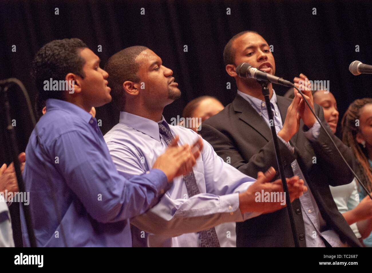 Close-up of three Johns Hopkins University Gospel Choir singers, from the waist up, performing during an event, February 11, 2006. From the Homewood Photography collection. () Stock Photo