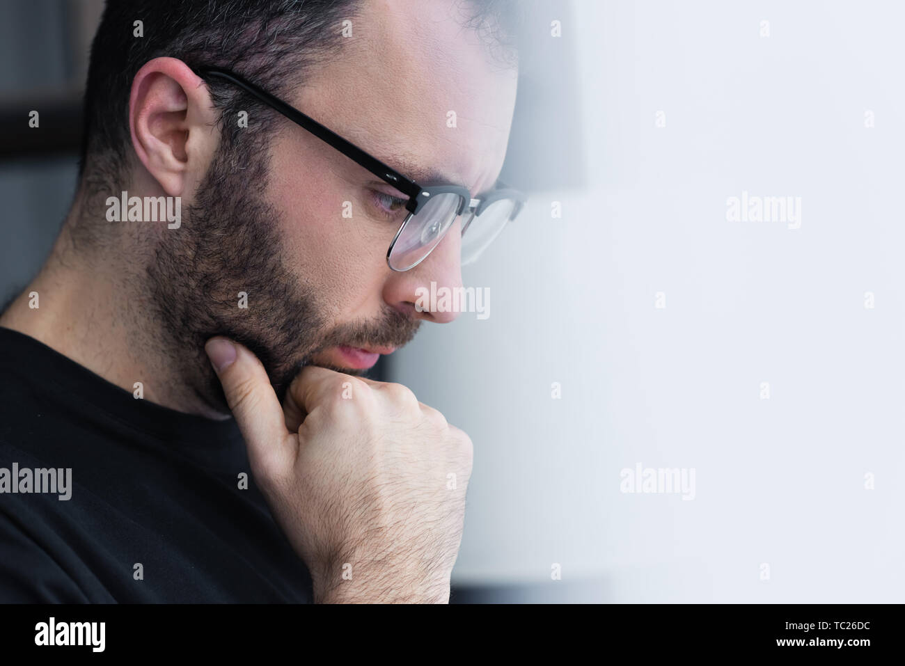 selective focus of thoughtful man in glasses holding hand near face and ...