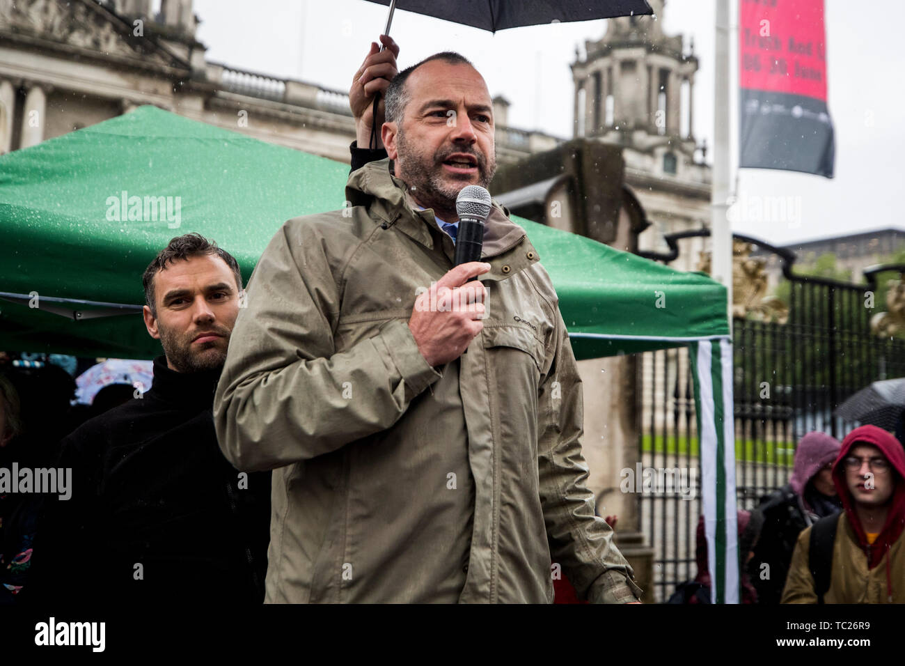 Patrick Corrigan of Amnesty International UK speaking during a 'Stop Trumpism' rally hosted by ExAct: Expat Action Group NI, at Belfast City Hall. Stock Photo