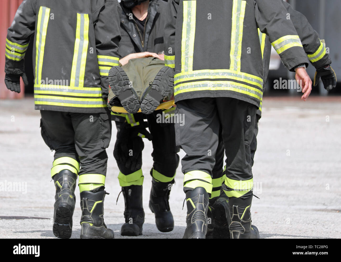 Firefighters Carrying An Injured Man On A Stretcher After A Fire Stock 