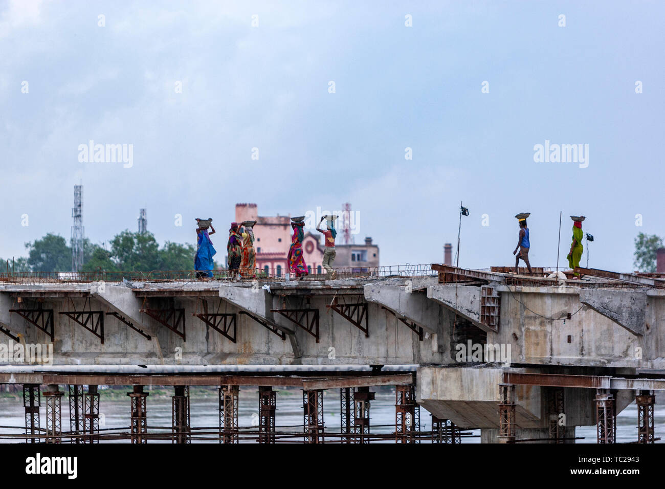 Women workers building a bridge under construction over Yamuna River
