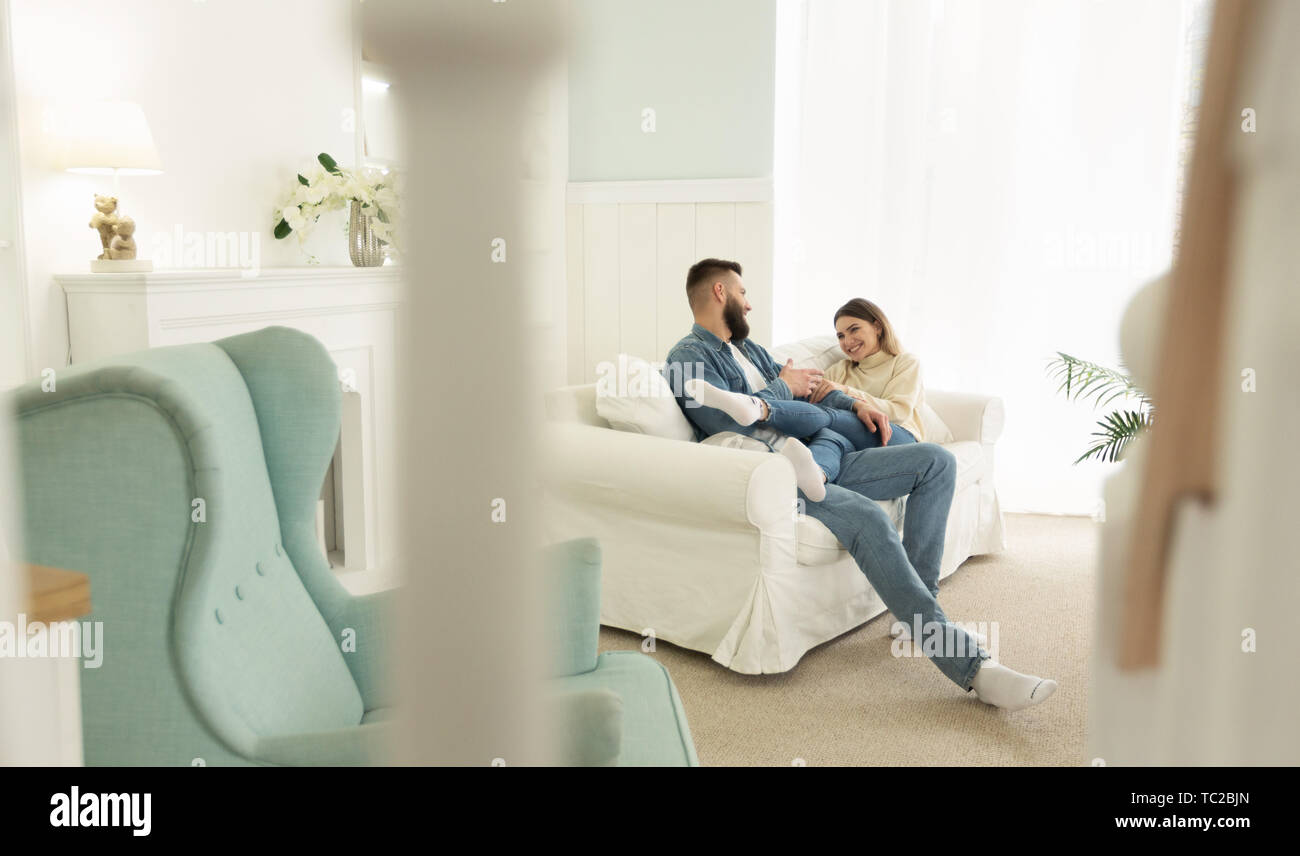 Loving Couple Relaxing On Sofa In Living Room Stock Photo - Alamy