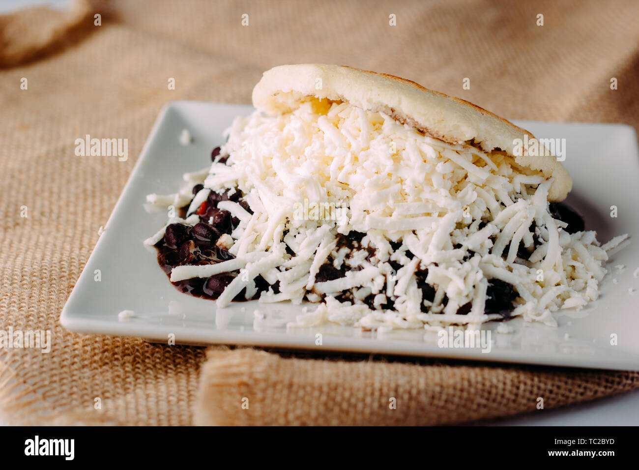 Delicious arepa stuffed with black beans and grated white cheese Stock Photo
