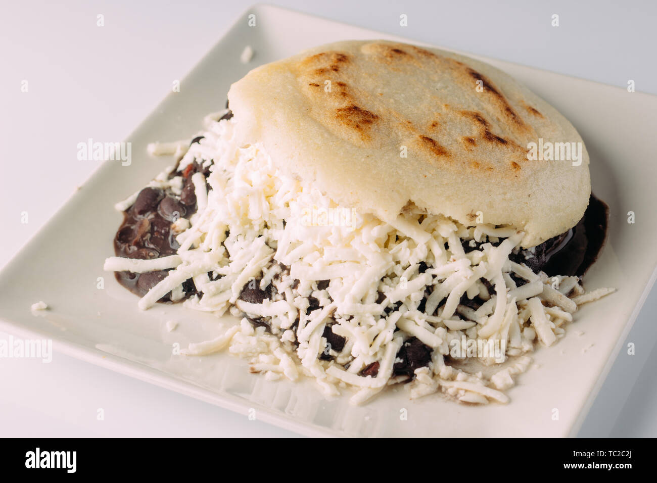 https://c8.alamy.com/comp/TC2C2J/delicious-arepa-stuffed-with-black-beans-and-grated-white-cheese-TC2C2J.jpg