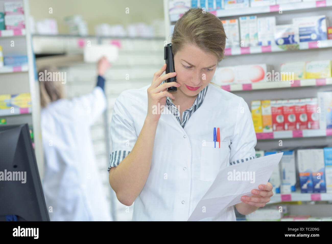 pharmacist reading the list on the telephone Stock Photo