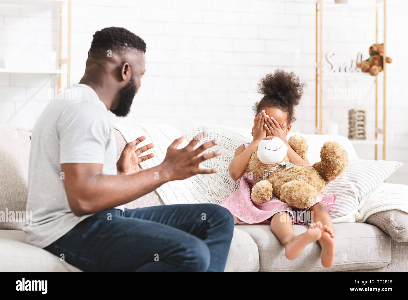 Angry african american father yelling at his little daughter Stock Photo