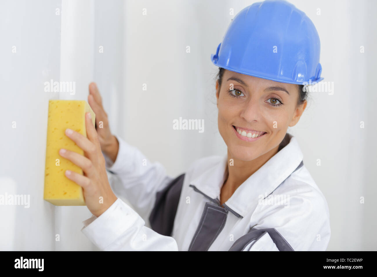 female builder using sponge on wall Stock Photo - Alamy
