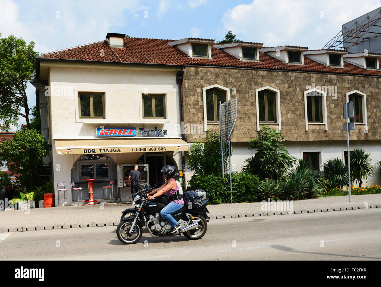 A motorbike passing by the popular BBQ Tanjga restaurant in Kotor Stock