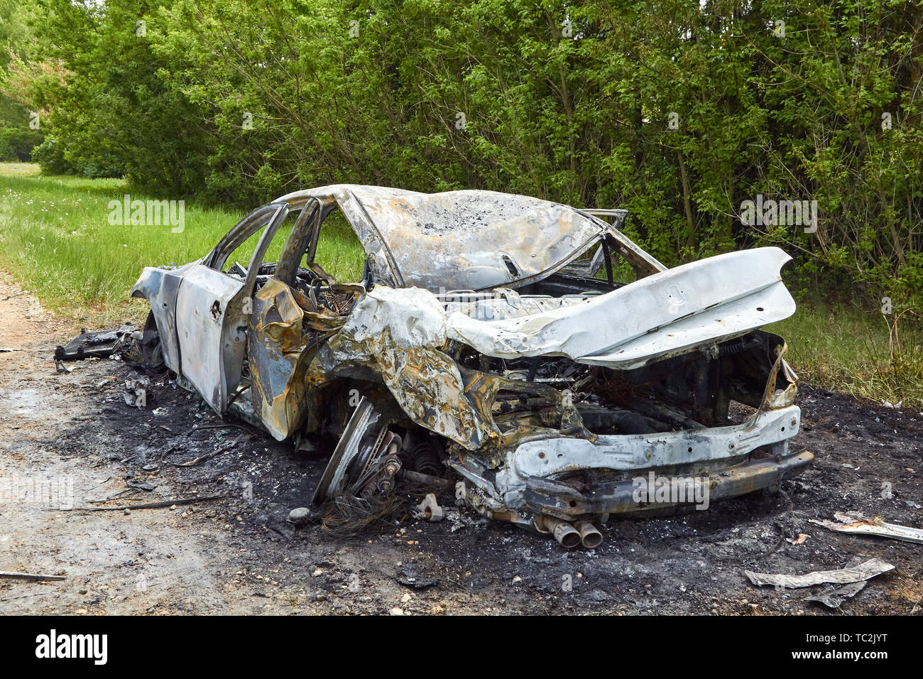 Fully burned car after collision with truck in summer, accident background Stock Photo