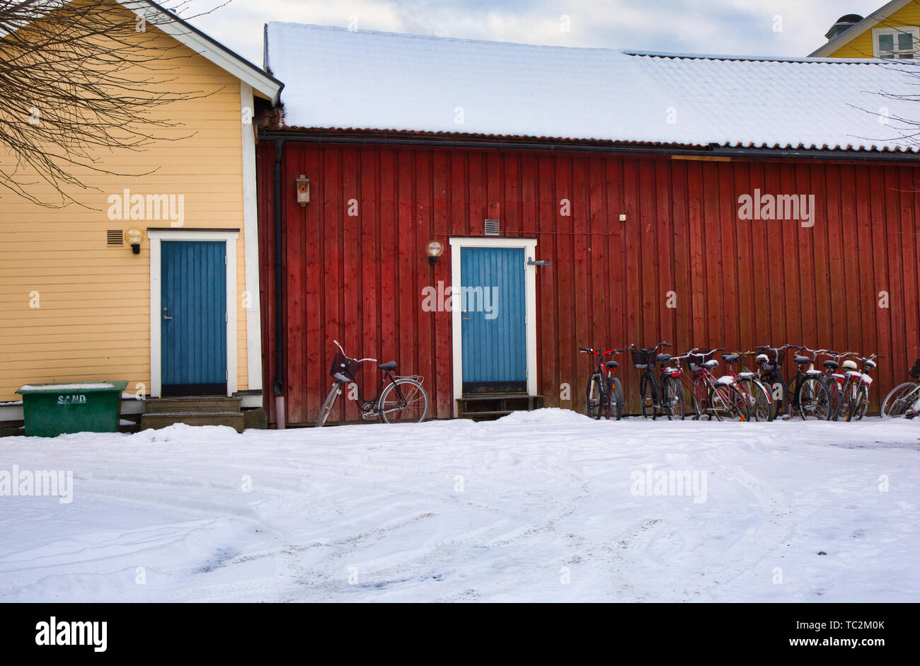 Bikes outside traditional timber buildings in winter, Sweden, Scandinavia Stock Photo