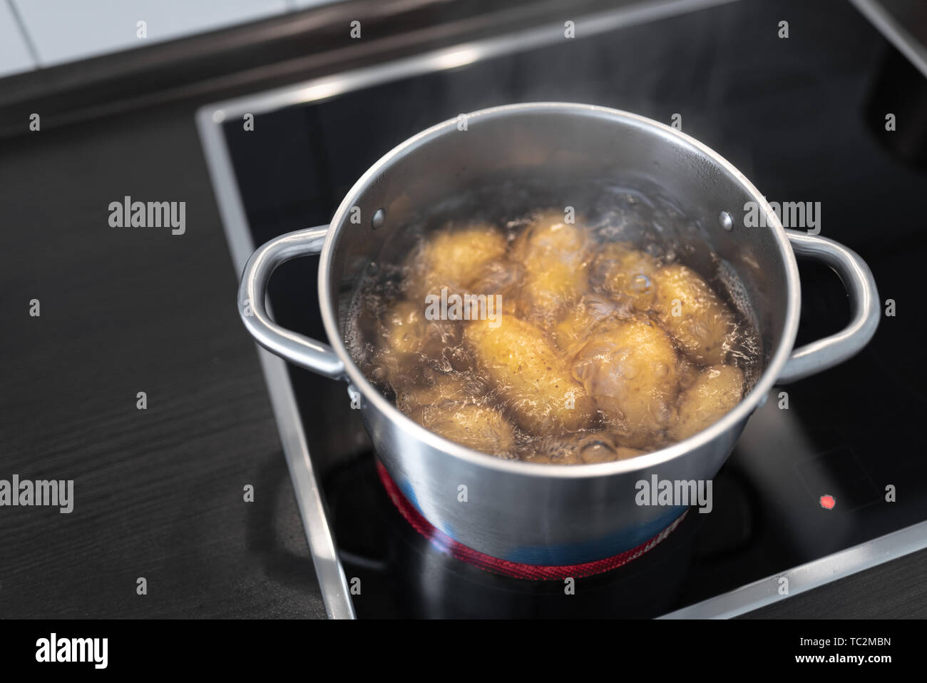 high angle view of pot with boiling water and potatoes on stove Stock Photo