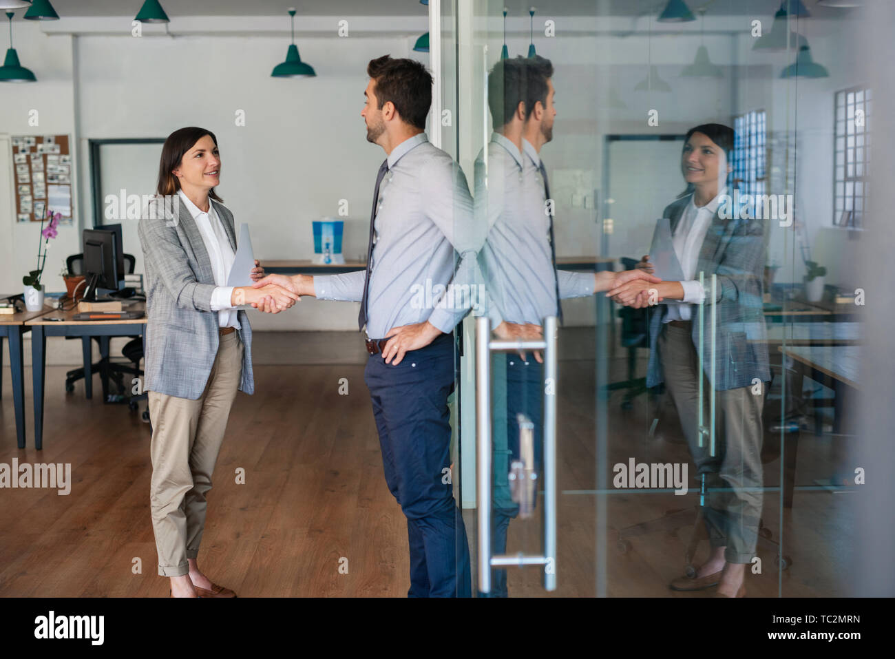 Businessman shaking hands with a new employee in an office Stock Photo