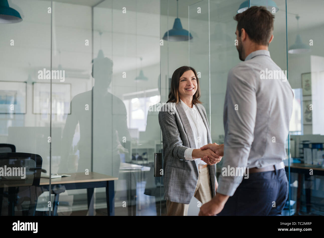 Manager smiling while welcoming a new office employee Stock Photo