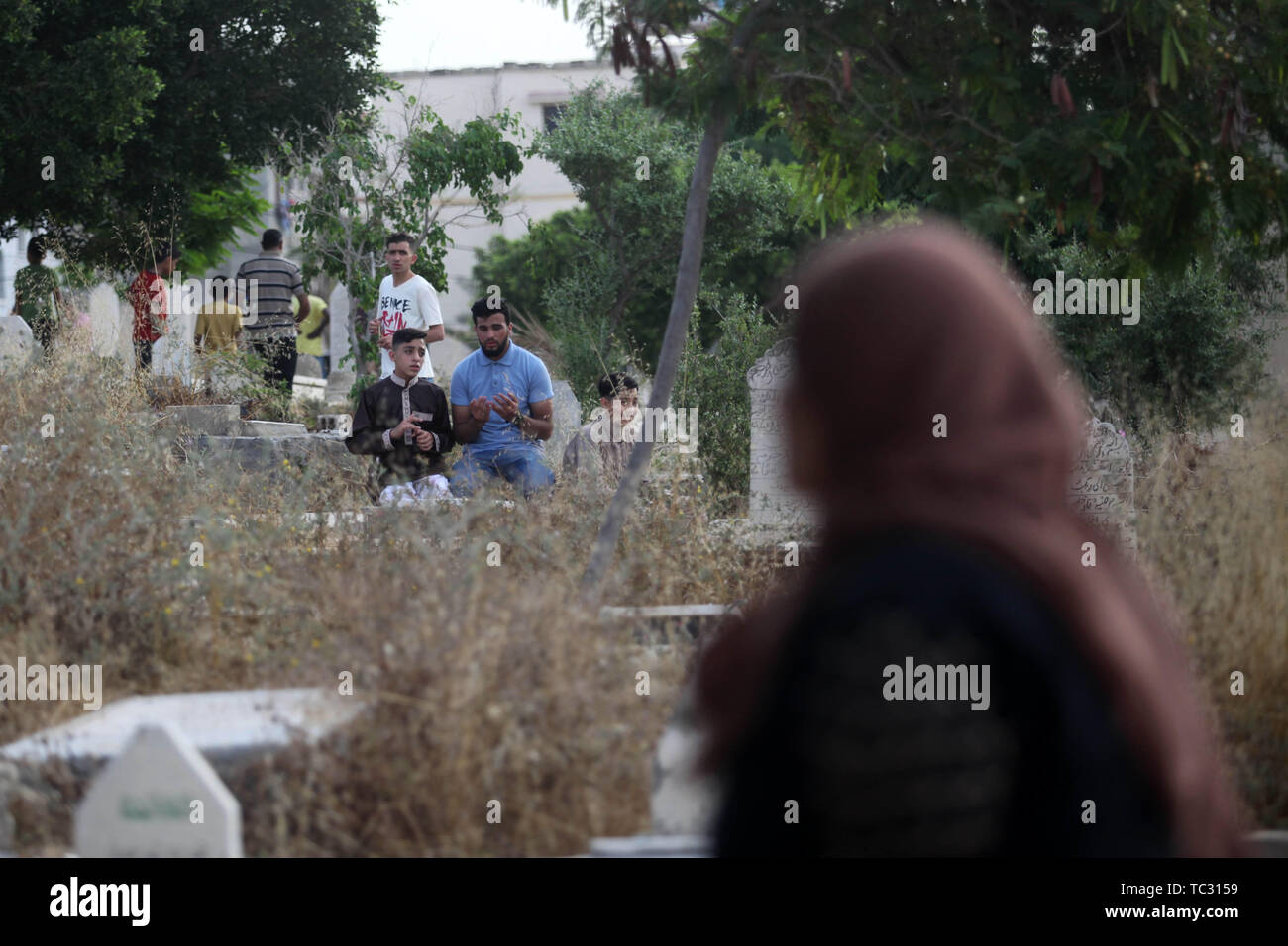 Gaza, Gaza Strip, Palestinian Territory. 5th June, 2019. Palestinians visit the graves of their relatives at a cemetery during the first day of Eid al-Fitr holiday which marks the end of the Muslim holy month of Ramadan, in Gaza city on June 5, 2019 Credit: Mahmoud Ajjour/APA Images/ZUMA Wire/Alamy Live News Stock Photo