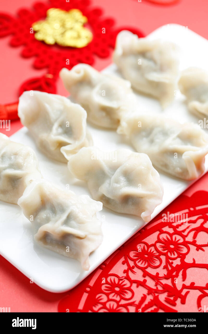 Spring Festivl dumplings and paper-cut on red background Stock Photo