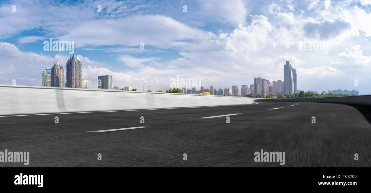 The foreground is the Zhengzhou urban landscape and urban skyline of asphalt road Stock Photo