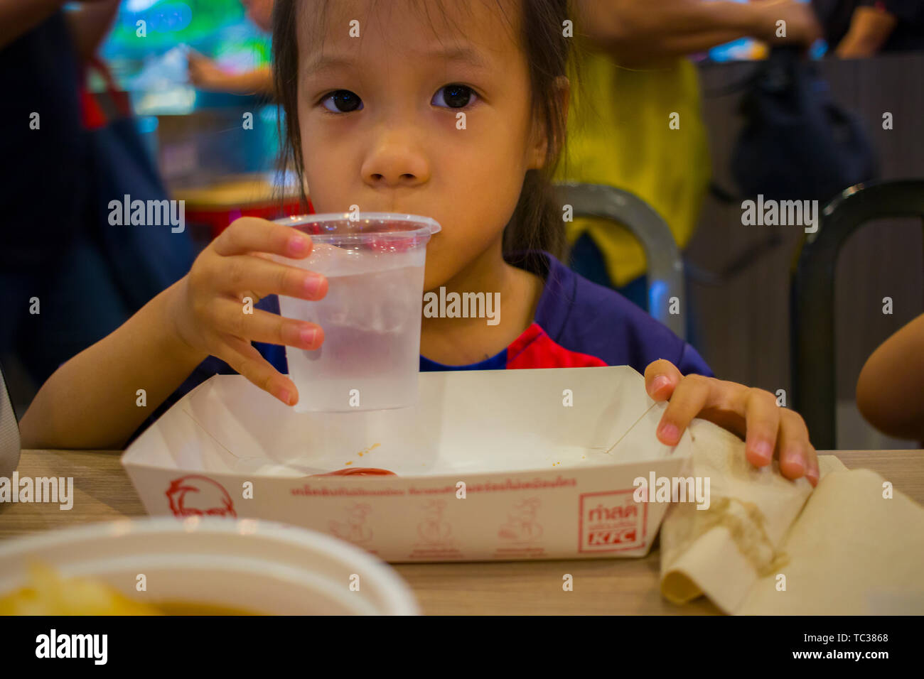 CHIANGMAI,THAILAND-MAY 3,2019 : Little Child eating fried chicken in the background of KFC restaurant. Stock Photo