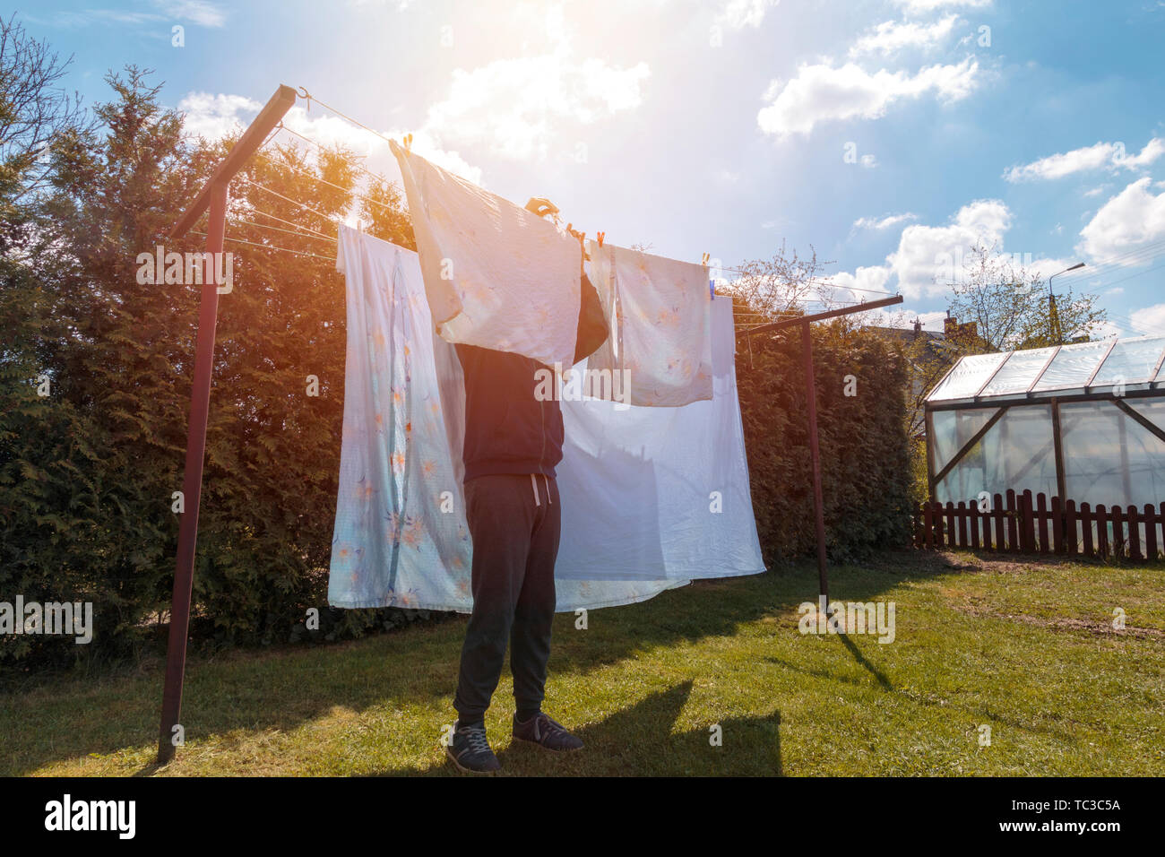 Drying the laundry. Man doing household chores and hanging the laundry Stock Photo