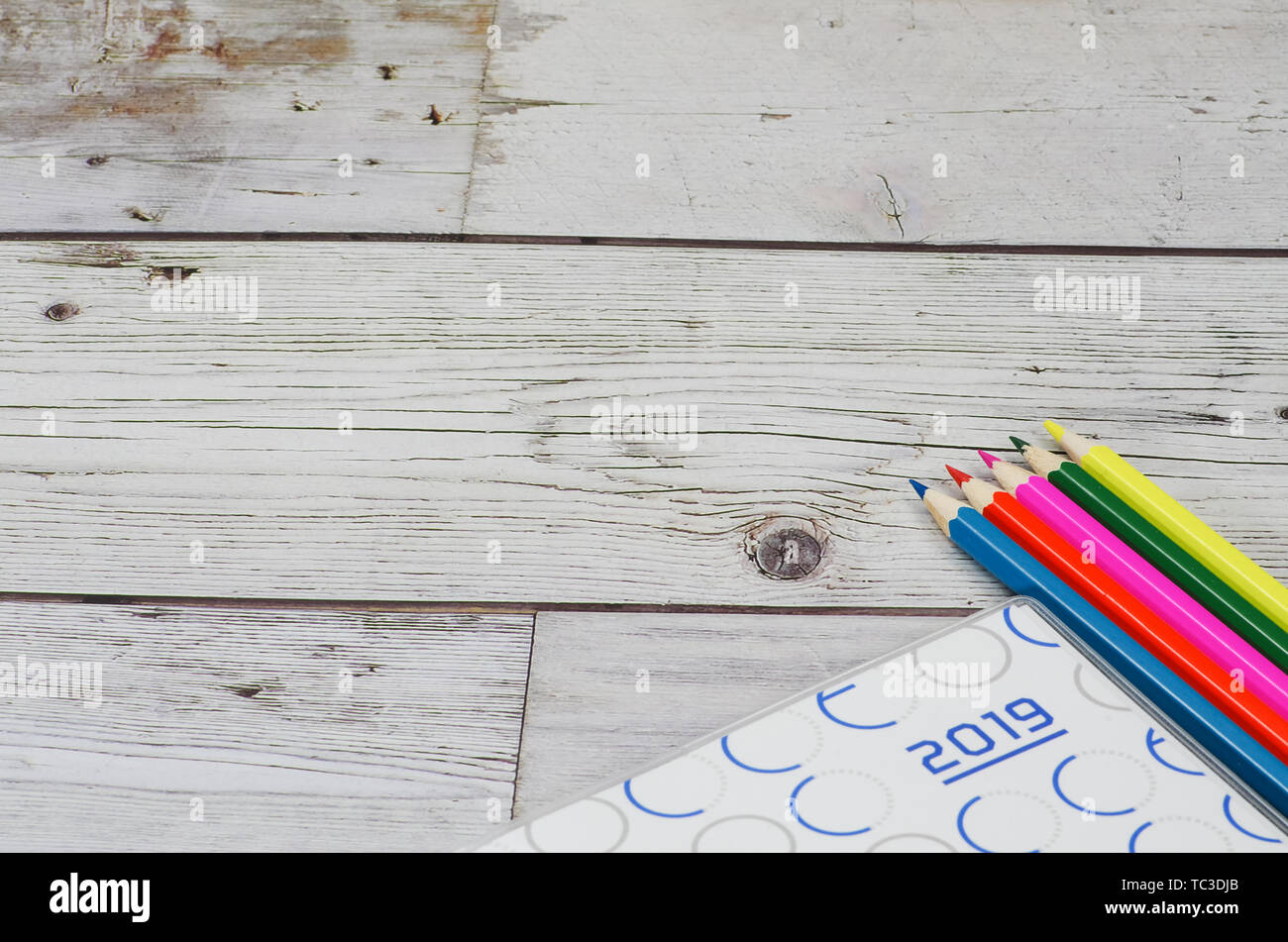 Colored pencil in wood grain background and 2019 efficiency manual